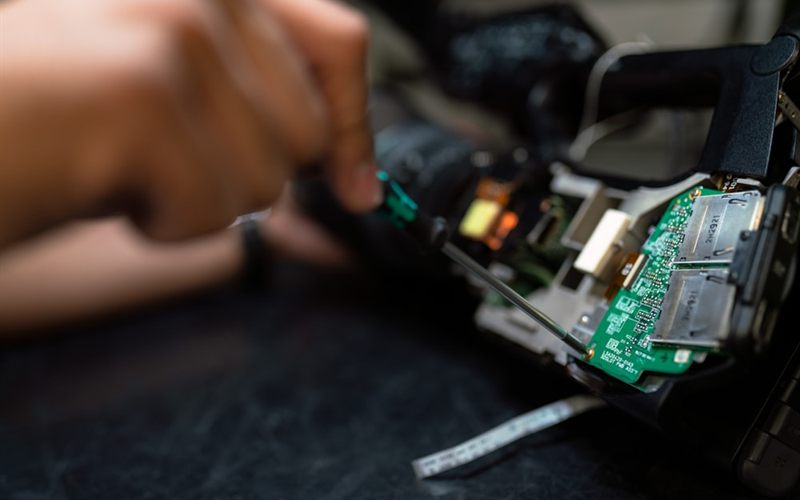 Anakart üzerinde onarım yapan teknisyen